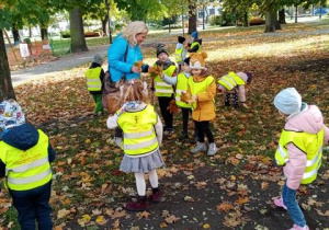 Dzieci zbierają liście w parku.
